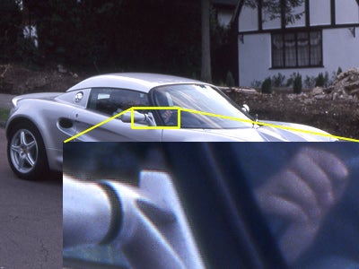 Product review image demonstrating the scanning quality and detail captured by the Epson Perfection 3170 Photo scanner, featuring a side-by-side comparison of a car with a zoomed-in inset showing textural details.