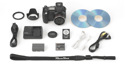 Canon PowerShot Pro1 camera and accessories laid out on a white surface, including the camera body, lenses, charger, batteries, remote control, cables, and software CDs.