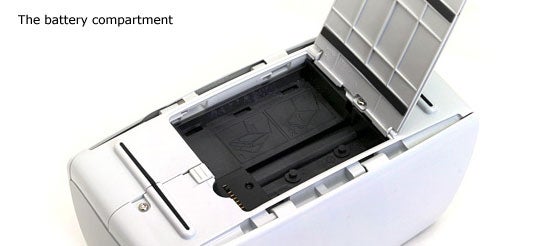 Open battery compartment of the HP Photosmart 375 Portable Photo Printer showing the battery slot and contacts.