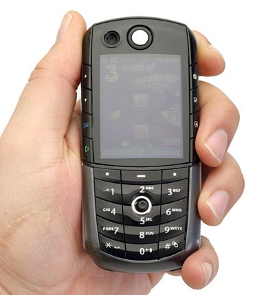 Hand holding a Motorola E1000 - 3G Mobile Phone showing its front display and keypad.