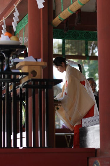 Close-up photo showcasing the depth of field and color reproduction capabilities of the Canon EOS 20D Digital SLR camera, featuring a person in the foreground with emphasis on detail and blur in the background.A photo taken with the Canon EOS 20D showing a traditional Japanese Shinto priestess in ceremonial attire performing a ritual inside a shrine.