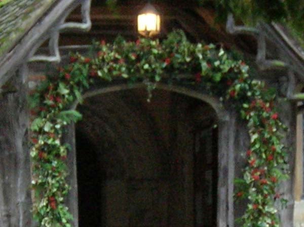 Photo taken with Nikon CoolPix 4800 showing an arched doorway with decorative greenery and a lit lantern above.