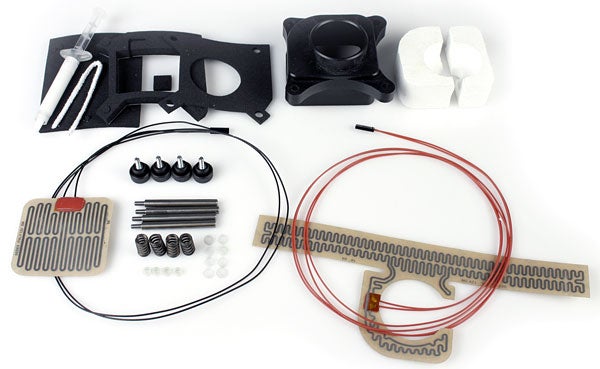 Components of Asetek VapoChill XE II Refrigerated PC Case laid out on a white surface, including cooling pipes, fan, mounting brackets, and other various installation parts.