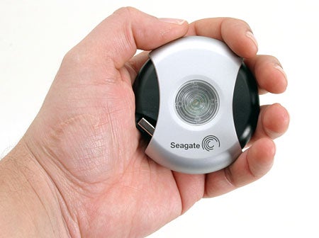 Hand holding a Seagate 5.0GB USB 2.0 Pocket Hard Drive, showcasing its compact size and distinctive design.