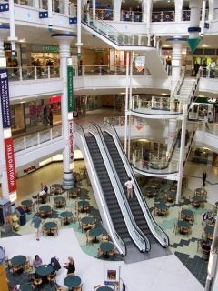 Photo taken with Kodak EasyShare Z700 showing an indoor multi-level shopping mall with escalators, seating areas, and various shops.