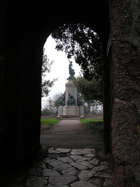 View through an archway leading to a statue monument, captured with the Konica Minolta DiMAGE Z20 camera.