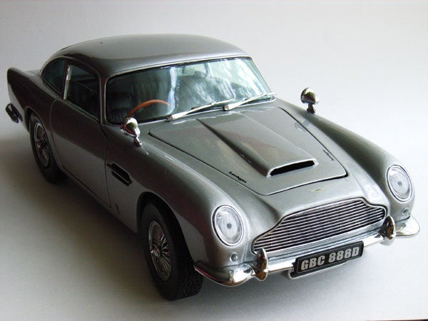 Product review image of a scale model Aston Martin car, possibly used to demonstrate the image quality of the Ricoh Caplio R1V digital camera.Close-up of a metallic object with a reflective surface, possibly part of the Ricoh Caplio R1V digital camera showing a distorted reflection.