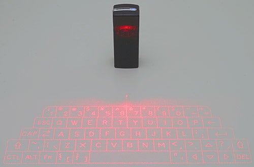 i.Tech Bluetooth Virtual Keyboard projecting a red laser keyboard layout onto a flat, light-colored surface with the device standing upright at the top center.