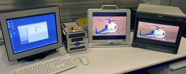Three monitors connected to a Matrox Parhelia APVe graphics card, displaying multi-screen functionality with a desktop interface and 3D applications running concurrently.
