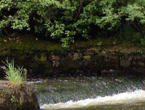 Sample image taken with an HP Photosmart M417 Digital Camera showcasing a small waterfall with surrounding greenery, demonstrating the camera's image quality.