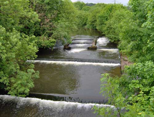 Photo taken with an HP Photosmart M417 digital camera showcasing a serene river with cascading weirs surrounded by lush greenery.