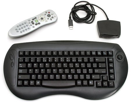 Photo showing accessories of the Hi-Grade DMS II - Media Center PC, including a wireless keyboard, remote control, and receiver.