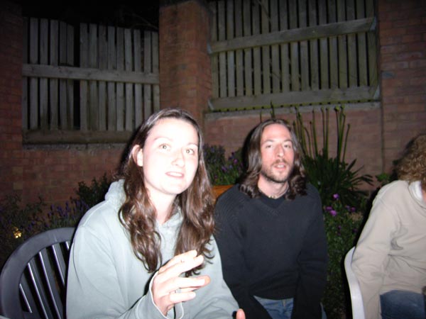 Low-light photo of two people taken with a Ricoh Caplio GX8 digital camera, showing flash use and nighttime image quality.