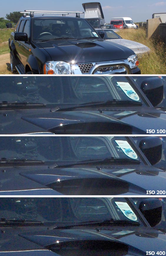 A series of photos taken with the HP Photosmart M22 digital camera showing comparisons of image noise at ISO 100, ISO 200, and ISO 400, illustrated by cropped images of a car's side mirror and environment reflections.
