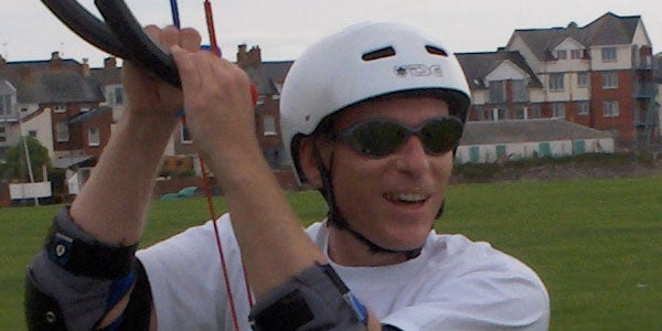 Person wearing sunglasses and a helmet while engaging in an outdoor activity, possibly paragliding, captured with the HP Photosmart M22 Digital Camera.