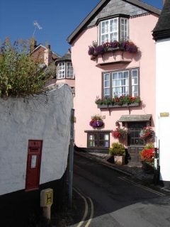Photo of quaint pink building with flower boxes taken by camera.