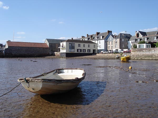 Seaside scene with boats and houses, captured in daylight.