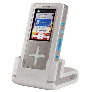 Toshiba Gigabeat F20 Portable Audio Player displayed in its docking station with the screen showing the menu interface including album, genre, playlist, folder, and bookmark options.