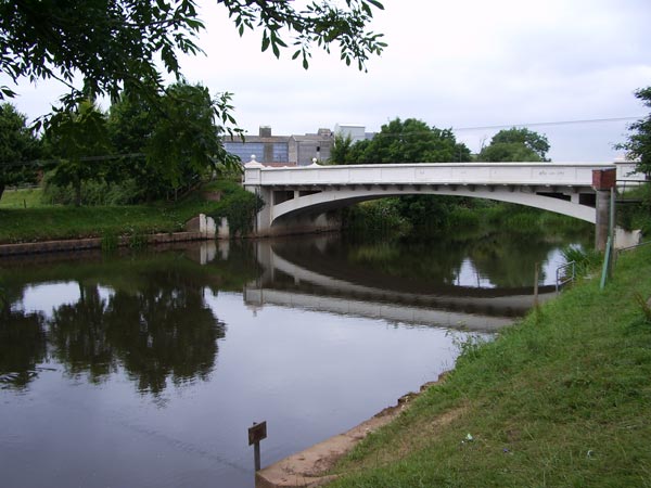 Photograph taken with a Pentax Optio S45 Digital Camera showing a calm river with a reflection of a bridge and trees, overcast sky above.Blurry photo of a white bridge taken with the Pentax Optio S45 digital camera, demonstrating image quality.