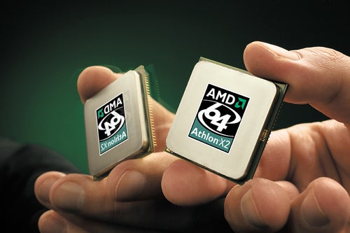 Two AMD Athlon X2 3800+ CPUs held between fingers, showcasing the logo and processor details.