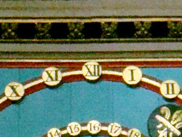 Close-up of an ornate clock face with Roman numerals, not related to the 