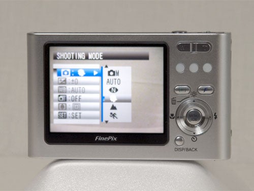 Rear view of a Fujifilm Z1 camera displaying the shooting mode options on its screen, set against a neutral background.
