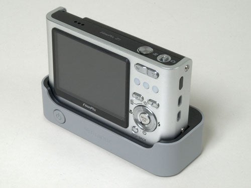 Fujifilm Z1 digital camera placed in its docking station against a plain background.