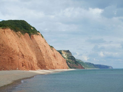 Photograph of a coastline with red cliffs and a clear sky taken with the Fujifilm Z1 camera.