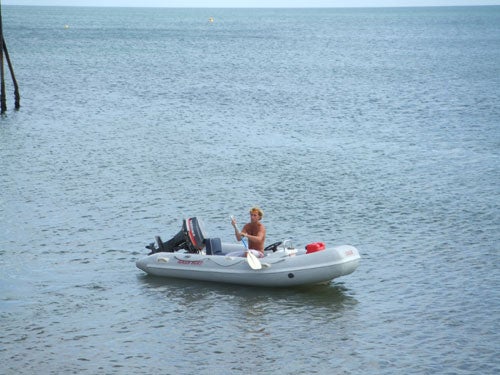 Photograph taken with a Fujifilm Z1 camera, featuring a person sitting in an inflatable boat on calm waters.