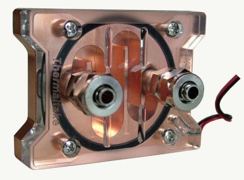 Close-up view of the Thermaltake Bigwater SE water block with transparent casing, showing internal copper pipes and connector fittings, with a red and black wire visible on the side.