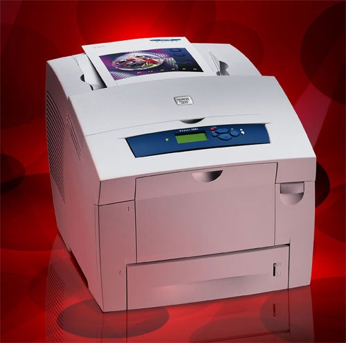 Xerox Phaser 8550DP Printer on a red background with a color printout emerging from the device, showcasing print quality.