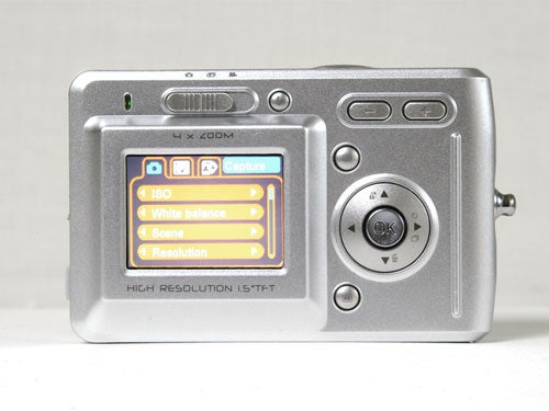 Goodmans G-Shot 3027TFT budget digital camera displayed on a neutral background, showing the camera's rear LCD screen with menu options including ISO, white balance, scene, and resolution settings.