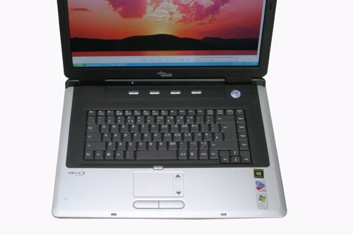 Front view of the open Fujitsu-Siemens AMILO M3438G Gaming Notebook with a sunset wallpaper on the screen, showing the keyboard and touchpad.
