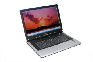 Fujitsu-Siemens AMILO M3438G gaming notebook on white background, showcasing its open display with a vibrant sunset wallpaper.