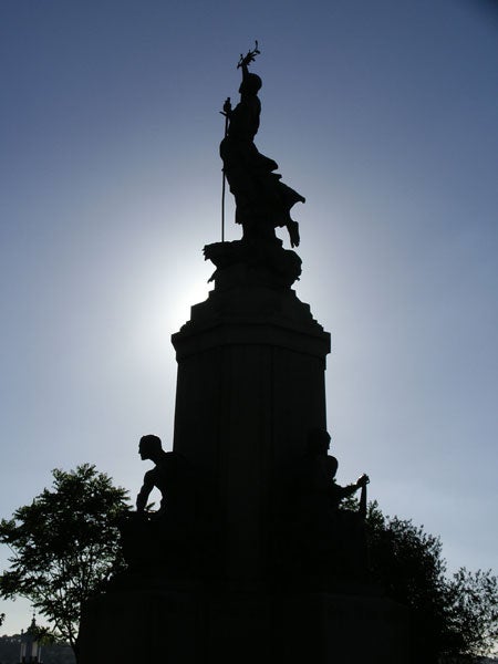 Silhouette of a statue against a bright sky, demonstrating the contrast capabilities of the Pentax Optio SVi digital camera.