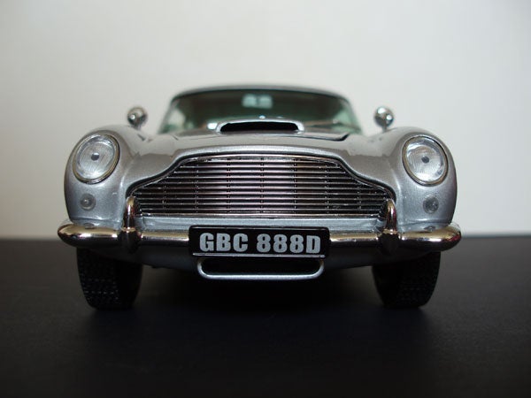 Front view of a silver model Aston Martin car with license plate GBC 888D on a black surface, possibly an example of macro photography showcasing the Olympus µ [mju] Digital 800 camera's capabilities.