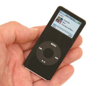 A hand holding a black Apple iPod nano showing the music player interface with artist and song information displayed on the screen.