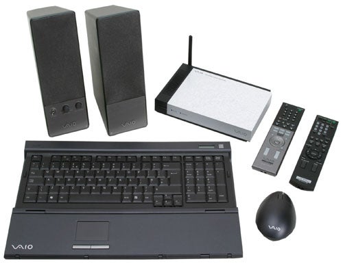 Sony Vaio VGC-RA304 desktop computer with wireless keyboard, mouse, stereo speakers, remote controls, and wireless networking hub.