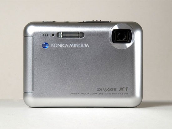 Konica Minolta Dimage X1 digital camera displayed on a light background, showing its silver exterior, lens, and branding details.