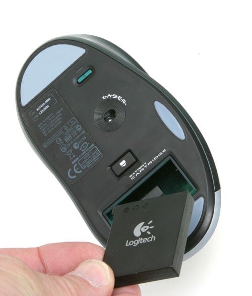 An image showing the underside of a Logitech G7 cordless 2000dpi Laser Mouse with a hand removing the rechargeable battery from its compartment.