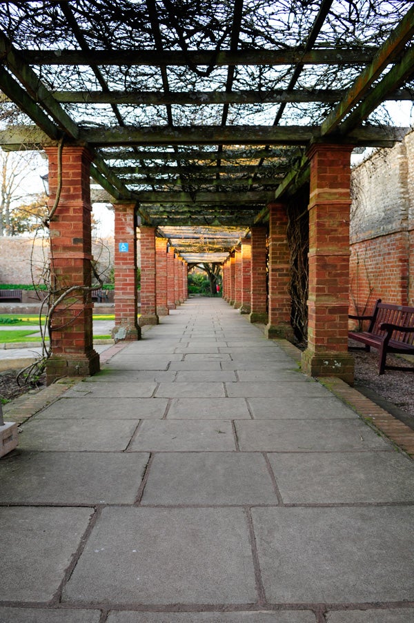 The image you've provided is of a garden pergola with a pathway underneath it, not related to the Creative Gigaworks ProGamer G500 or any product review. Please provide the correct image or context for a description.