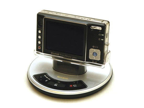 Kodak EasyShare V550 digital camera displayed on a docking station with the lens closed and LCD screen facing forward.