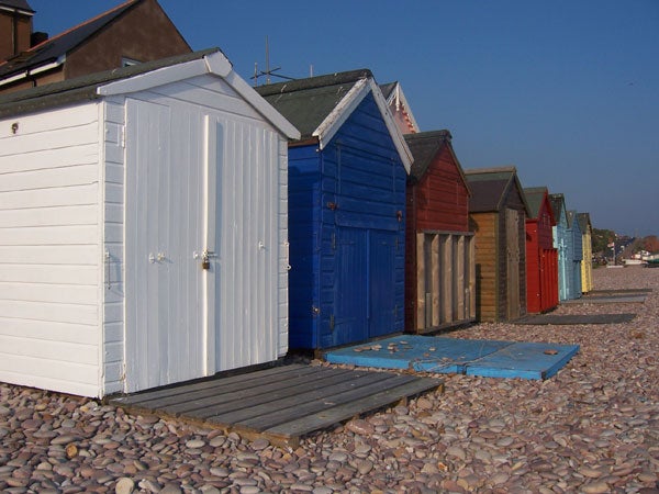 A row of colorful beach huts on a pebble beach under a clear sky, potentially demonstrating the image quality of the Kodak Easyshare V550 digital camera.