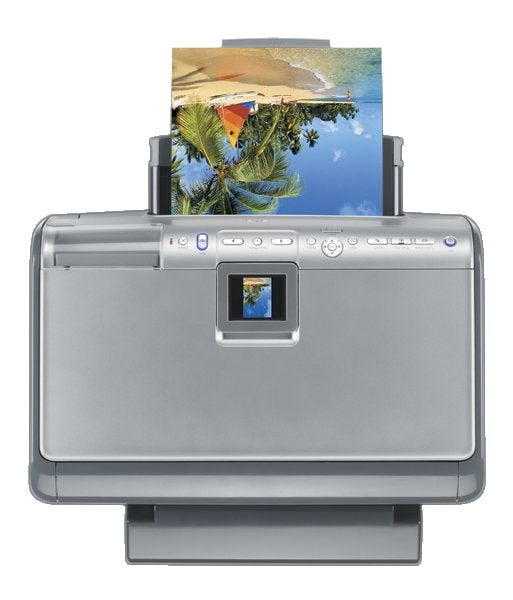 HP Photosmart 8250 printer with a photo printout featuring a tropical beach scene emerging from the top slot, demonstrating the printer's color output capabilities.