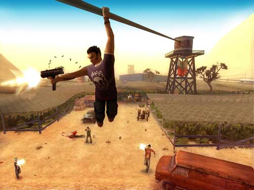 Screenshot from the video game Total Overdose showing the protagonist hanging from a pipe and shooting at enemies below in a desert-like setting with a water tower and vehicles in the background.