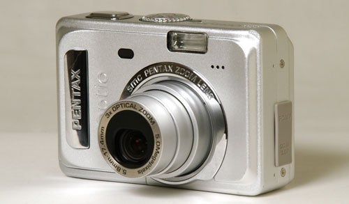 Pentax Optio S55 digital camera placed on a surface, with lens extended and focused, highlighting its 5.0 megapixel resolution and 3x optical zoom features.