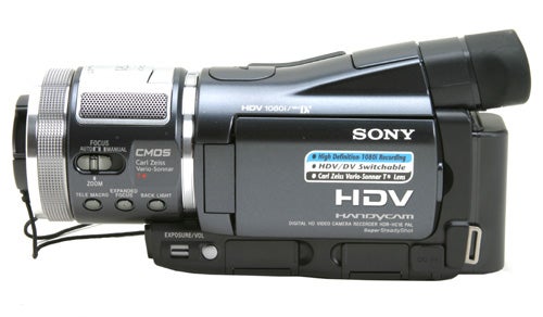 Sony HDR-HC1E High Definition Camcorder displayed against a white background, showcasing its side profile with focus ring, CMOS sensor label, Carl Zeiss lens, and the HDV 1080i marking.