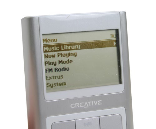 Close-up of a Creative Zen Sleek MP3 player showing the main menu with options such as Music Library, Now Playing, Play Mode, FM Radio, Extras, and System.