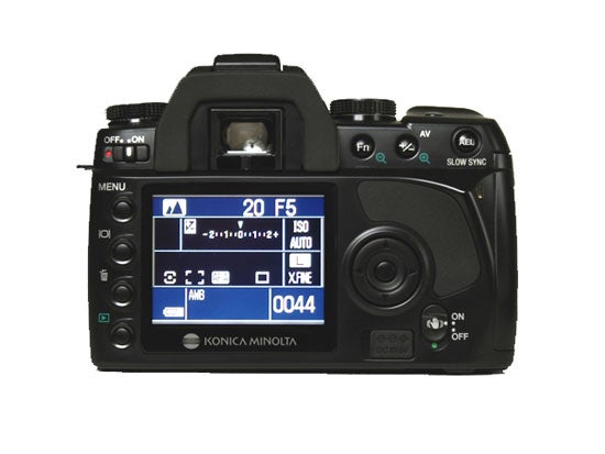 Konica Minolta Dynax 5D digital SLR camera showing LCD screen with settings display, including ISO, aperture, and shot count, and main control buttons on the back panel.