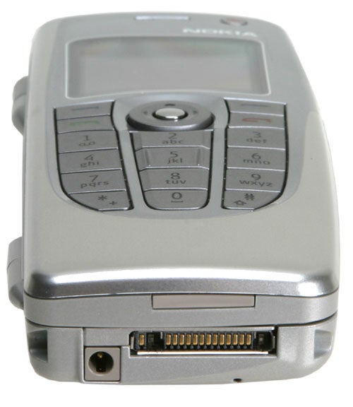 Nokia 9300 smartphone shown from a top-angle view focusing on the keyboard and screen, with power and port connections visible at the base of the device.